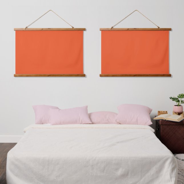 An orange square with a white border, creating a v hanging tapestry (Bedroom)