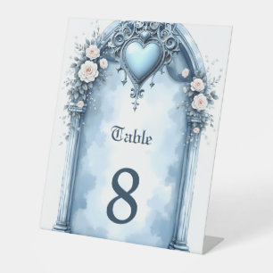 An ornate light blue archway with floral accents, pedestal sign
