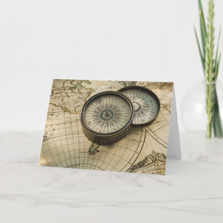 Antique compass on map card