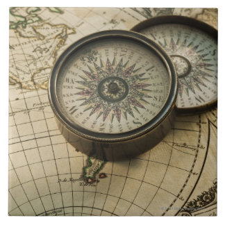 Antique compass on map tile