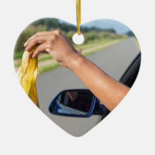 Arm dropping peel of banana out car window ceramic tree decoration