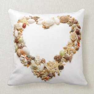 Assorted seashells form heart shape cushion