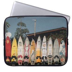 Assorted surfing boards stands on open field in th laptop sleeve