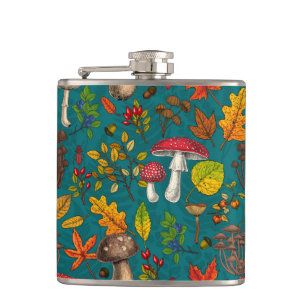 Autumn mushrooms, leaves, nuts and berries on blue hip flask