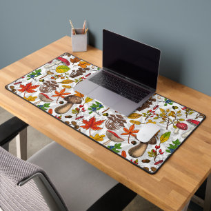 Autumn mushrooms, leaves, nuts and berries on whit desk mat