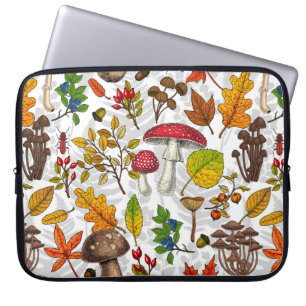 Autumn mushrooms, leaves, nuts and berries on whit laptop sleeve