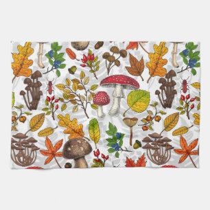 Autumn mushrooms, leaves, nuts and berries on whit tea towel