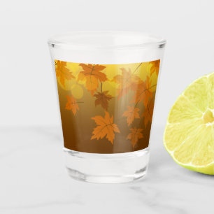 Autumn pattern with falling maple leaves and bokeh shot glass