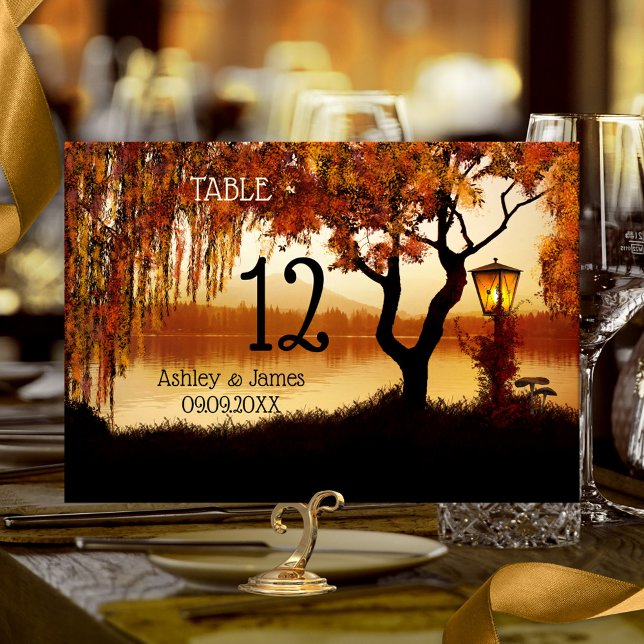 Autumn Tree Lake View Wedding Table Number Card (Fall wedding table number card featuring a colorful autumn tree and festive lantern at the waterside)