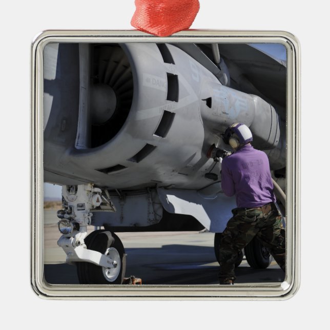 Aviation fuel technician attaches a fuel line metal tree decoration (Front)