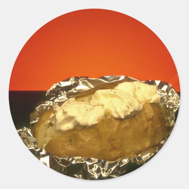 Baked potato with sour cream, against orange backg classic round sticker (Front)