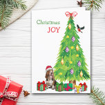Basset Hound Dog, Bird and Christmas Tree Holiday Card<br><div class="desc">On the front of this Christmas card, a happy Basset Hound dog wears a red and white Santa Claus hat while he sits beside a Holiday tree. Brightly wrapped gift packages are scattered about, and a bullfinch is landing on the Christmas tree. The red and green text says "Christmas JOY"....</div>