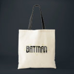 Batman Hi-Tech Name Graphic Tote Bag<br><div class="desc">This graphic design captures the timeless allure of Batman through a strikingly minimalist approach. The logo features the iconic Batman emblem in a bold, angular design that merges seamlessly with the word "BATMAN" set in stark, stylised letters. The design is presented in a monochromatic palette of black and white, highlighting...</div>