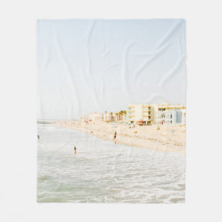 BEACH NEAR BUILDING AT DAYTIME FLEECE BLANKET