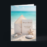 Beach Wedding Christmas With Starfish Holiday Card<br><div class="desc">A blank card and envelope rest on a sandy beach surrounded by seashells,  a starfish,  and a turquoise ocean background for newlyweds 1st Christmas together.
All text can be changed.</div>