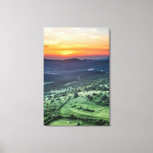 Beautiful sunset behind green fields canvas print