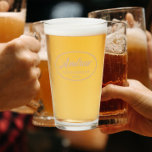 Beige Stylised Wedding Groomsman Name Glass<br><div class="desc">Beer glass for the wedding groomsman that features his name printed in a trendy beige colour, stylised script inside a beige colour oval border along with wedding year date. A great party supply idea for a bachelor party! Personalise your beer glass by editing and replacing name and date with your...</div>