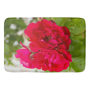 Big red roses in the garden bath mat