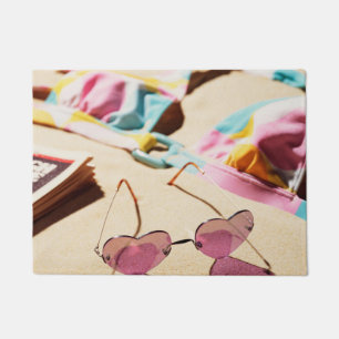 Bikini Top And Heart Shape Sunglasses On Beach Doormat
