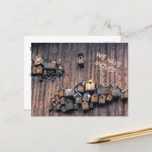 Bird house on a wooden wall, fun we haved moved postcard