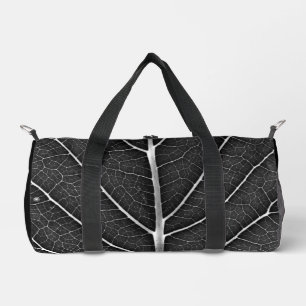 Black and white glowing leaf close-up duffle bag