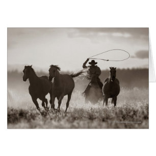 Black and White photo of a Cowboy Lassoing Horses