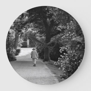 Black and white photo of old man at park large clock