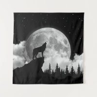 Black and white wolf howling at the moon