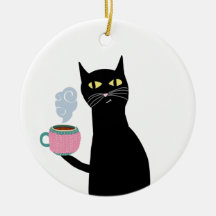 Black cat holding a cozy mug