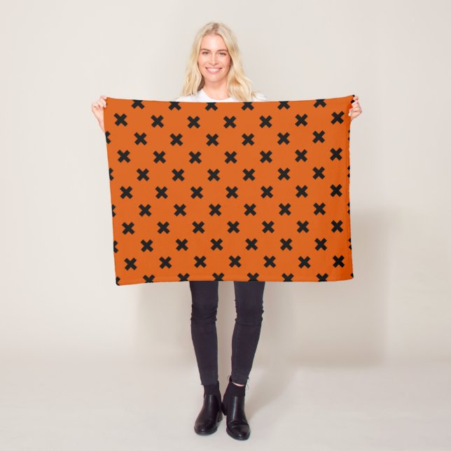 Black cross stitches on orange fleece blanket (In Situ)