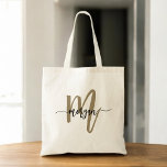 Black Gold Modern Script Monogram Name Tote Bag<br><div class="desc">Carry your essentials in style with the Black and Gold Modern Script Monogram Name Tote Bag. Featuring a sleek black canvas with a bold gold monogram in a modern script font, this tote bag blends elegance and functionality. Spacious enough for shopping, work, or daily use, it offers both style and...</div>