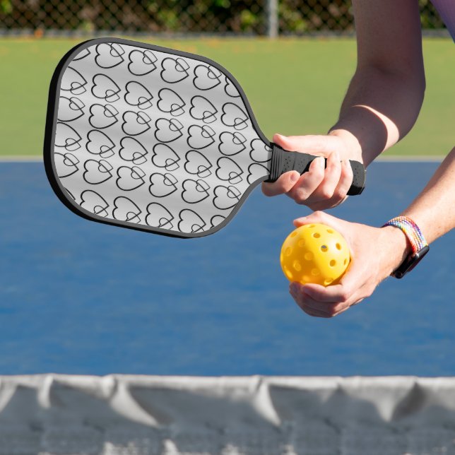 Black hearts on silver pickleball paddle (Insitu)