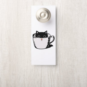 Black kitten with red nose hiding in a cup door hanger