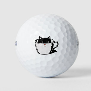 Black kitten with red nose hiding in a cup golf balls