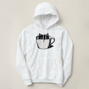 Black kitten with red nose hiding in a cup hoodie