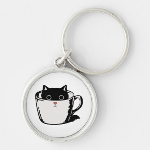Black kitten with red nose hiding in a cup key ring