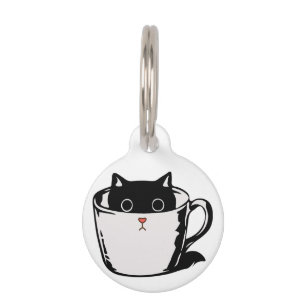 Black kitten with red nose hiding in a cup pet tag