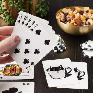 Black kitten with red nose hiding in a cup playing cards
