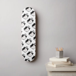 Black kitten with red nose hiding in a cup skateboard