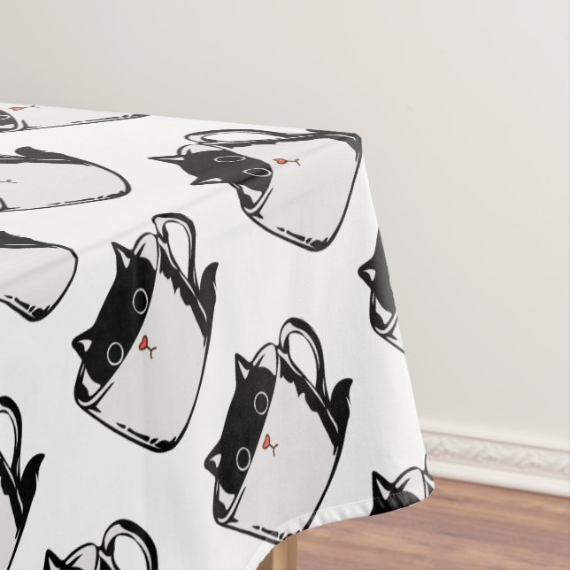 Black kitten with red nose hiding in a cup tablecloth (In Situ)