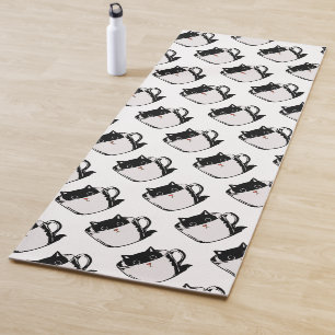Black kitten with red nose hiding in a cup yoga mat
