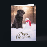 Black Labrador Christmas Snowman Card<br><div class="desc">A heartwarming Christmas card featuring a loyal Black Labrador sitting in fresh winter snow beside a cheerful little snowman wrapped in a red scarf. Warm golden winter light and softly falling snow create a peaceful holiday moment that captures the gentle spirit and faithful companionship Labrador Retrievers are known for. Perfect...</div>