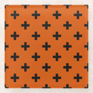 Black polka crosses on orange glass coaster
