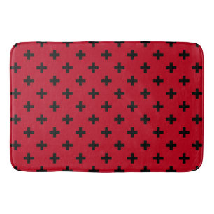 Black polka crosses on red bath mat