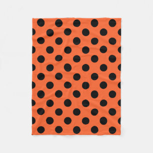 Black polka dots on orange fleece blanket