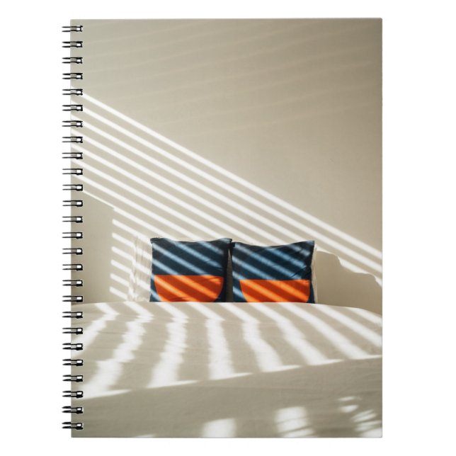 Black red and white plaid textile on white bed notebook (Front)