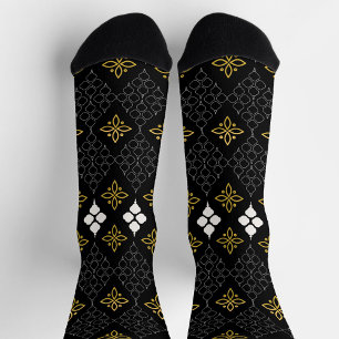 Black socks featuring a gold and white pattern