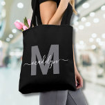 Black Trendy Modern Script Name Monogram Tote Bag<br><div class="desc">Personalised Elegant Black Trendy Modern Script Name Monogram Tote Bag. Add a touch of sophistication to your everyday style with this chic tote bag. Featuring a sleek grey initial centred on a crisp black background, with a clean and modern design on both sides, this tote combines elegance with practicality. Perfect...</div>