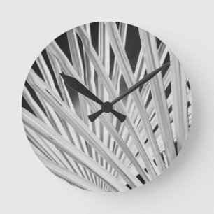 Black & White view of palm tree fronds Round Clock