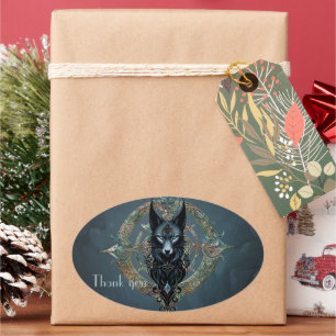 Black wolfs head with piercing blue eyes, oval sticker